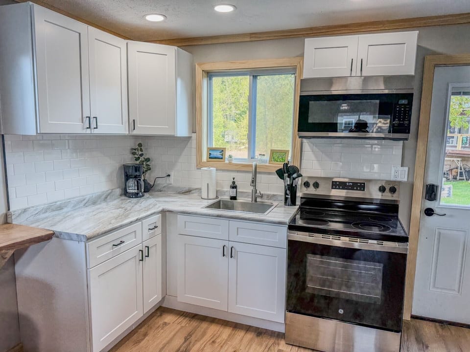 Bright modern kitchen with stainless appliances and sunny window views