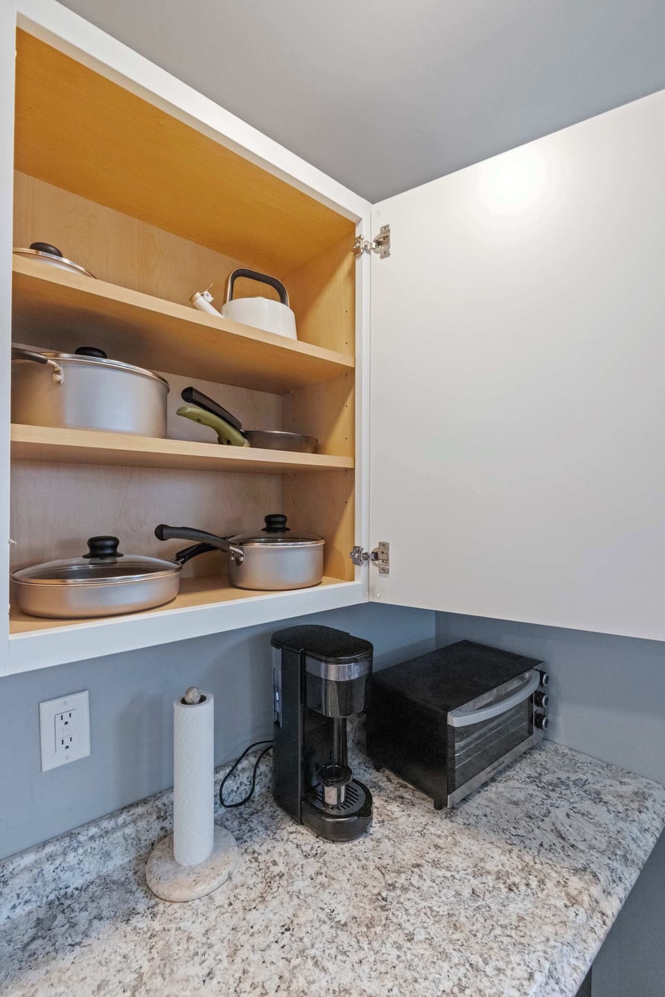 Coffee maker, toaster oven, and cookware ready for easy meal prep or a quick morning brew.