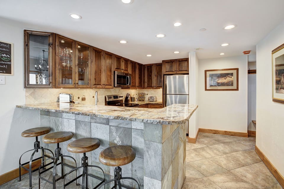 Kitchen with four counter stools for additional seating.