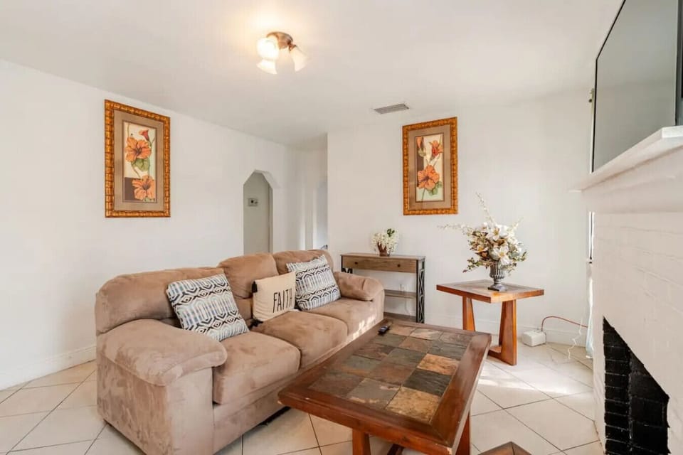 Cozy living room with a warm, homey feel, featuring an inviting accent rug and a charming brick wall that adds character to the space.