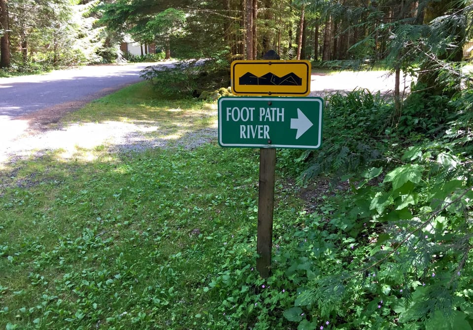 Clear directional sign to nearby footpath and river trail