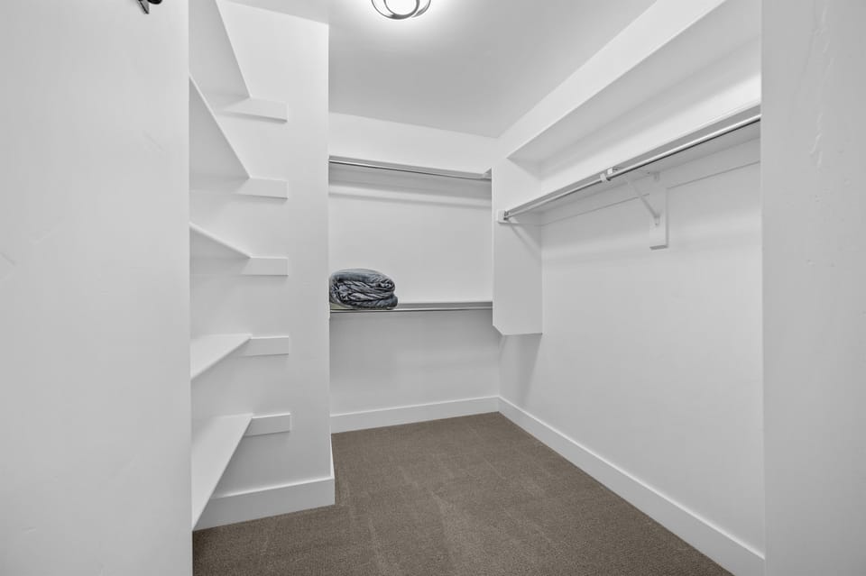 Spacious walk-in closet with built-in shelving and ample storage space.