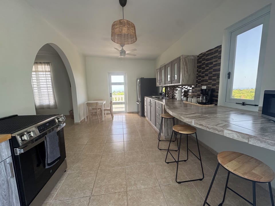 Kitchen with walk out to wrap around deck with panoramic ocean view.
