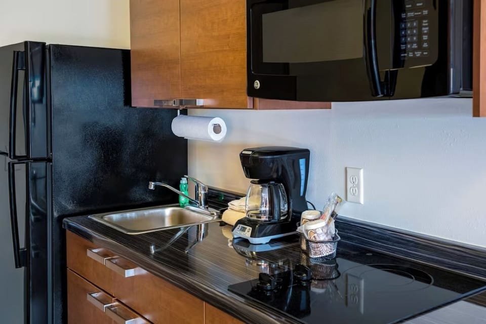 Kitchenette with full-sized refrigerator, double burner tempered glass stove top, coffee maker, and microwave
