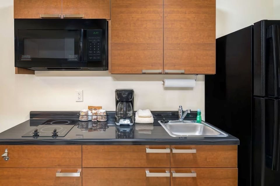 Kitchenette with full-sized refrigerator, double burner tempered glass stove top, coffee maker, and microwave