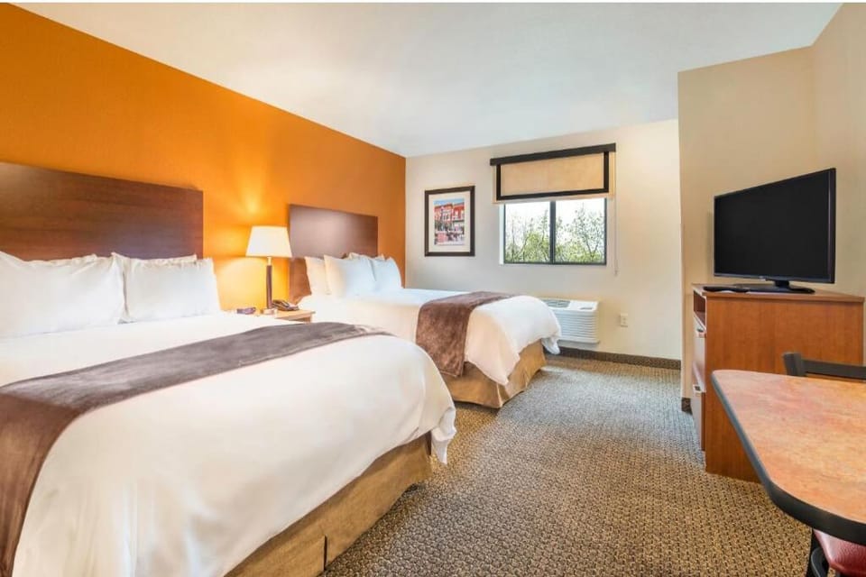Unwind in a bright double-queen room with cozy linens.