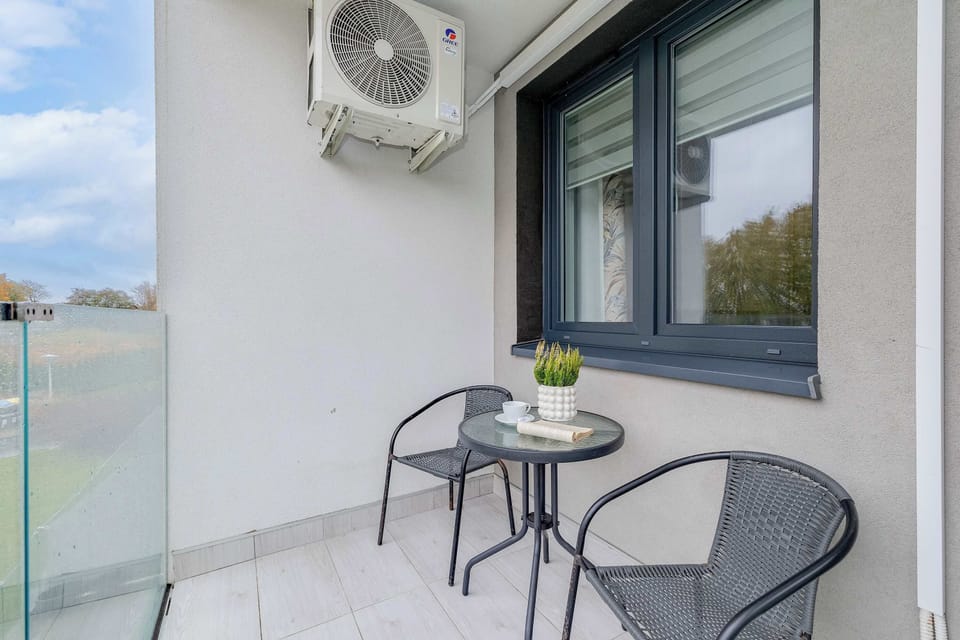 Balcony with a table and two chairs, perfect for enjoying morning coffee or fresh air.