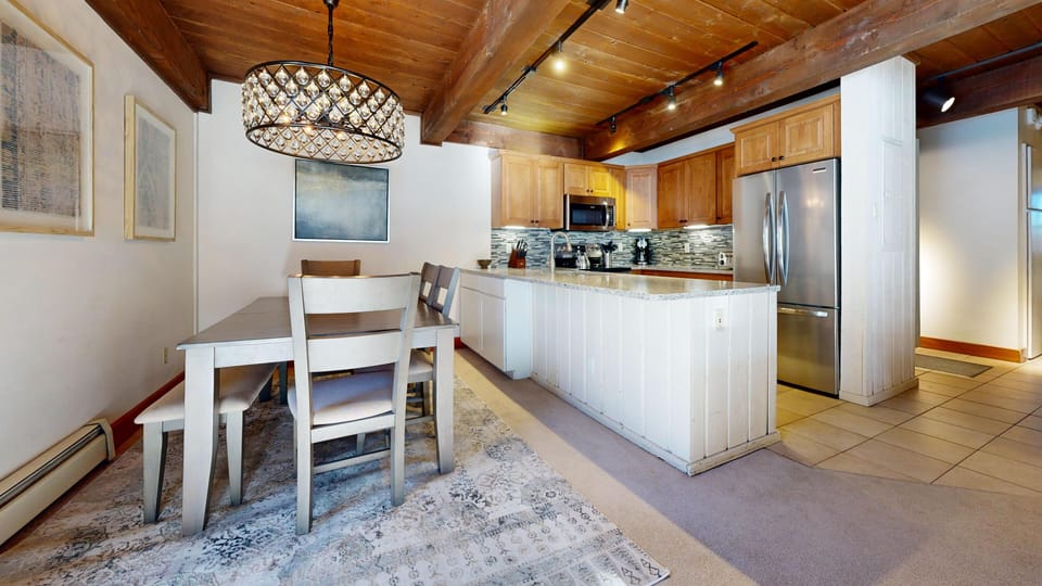 Step into your open-concept kitchen featuring warm wood beams, granite counters, and everything you need to create memorable meals together.