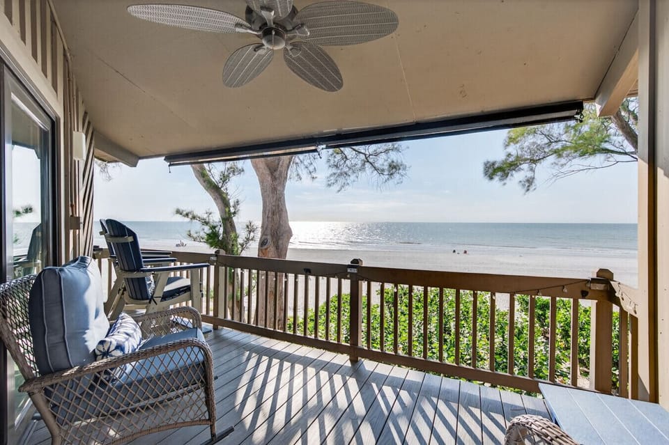 Relax on the covered balcony w/ comfy seating & leafy views, perfect for slow mornings or evening chats.