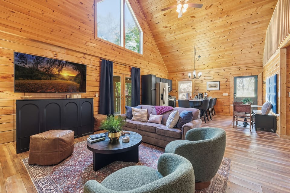 Gather in the open concept living room, where vaulted ceilings and warm wood tones create a cozy mountain vibe. Enjoy movie nights or the big game on the 75" smart TV, then unfold the queen Murphy bed for a restful night on the memory foam mattress.