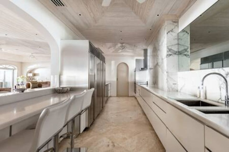 White marble modern kitchen with bar area, blender, breakfast bar, chef's kitchen, coffee maker, dishwasher, electric hob, juicer, kettle, microwave, Nespresso machine, oven, toaster, wine fridge