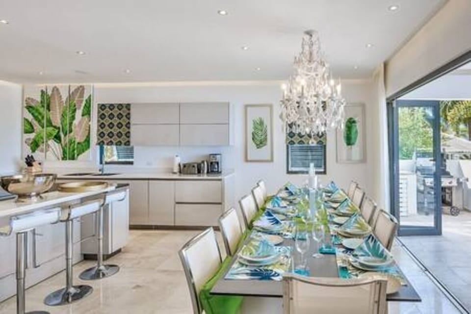 Full open plan kitchen with a breakfast bar, dining table and an array of appliances.
