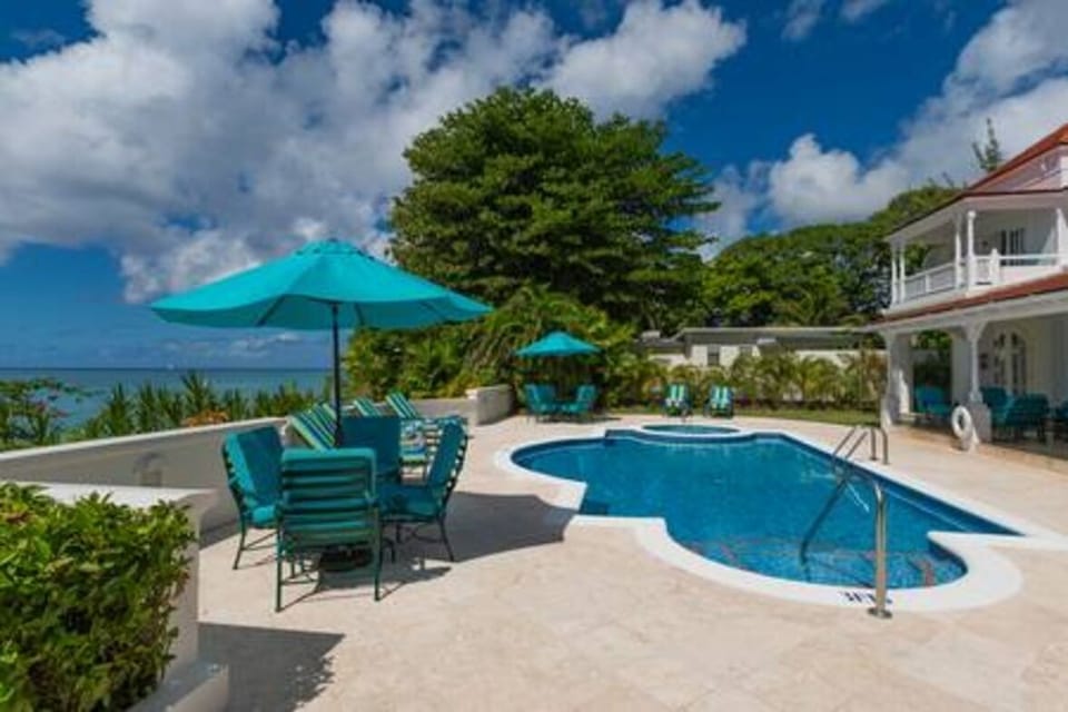 A serene pool area which leads down to the beach.  This area is provided with sun loungers, seating with parasol and beach towels.