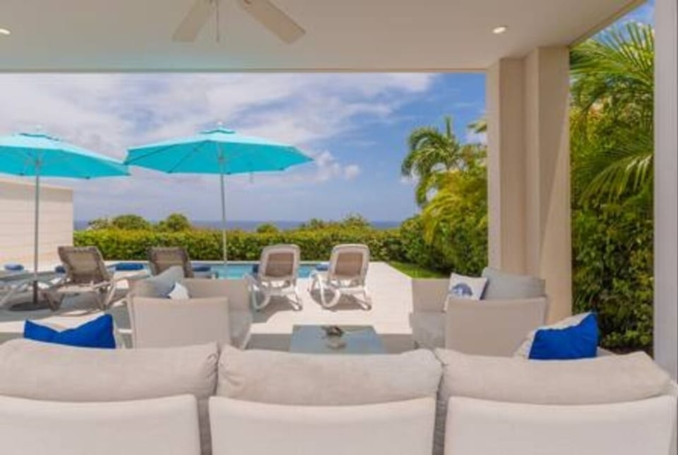 Outside living space with comfortable seating, dining area and a BBQ along with stunning sea views.