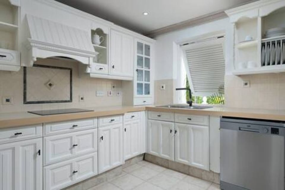 A fully equipped kitchen including a dishwasher, coffee maker, electric hob and microwave.