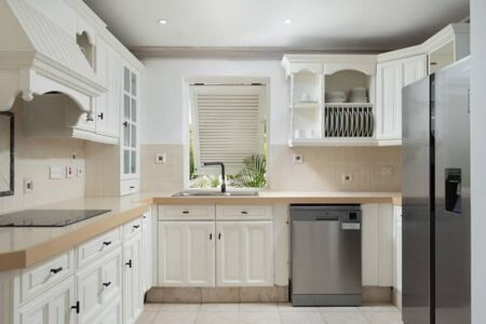 A fully equipped kitchen including a dishwasher, coffee maker, electric hob and microwave.