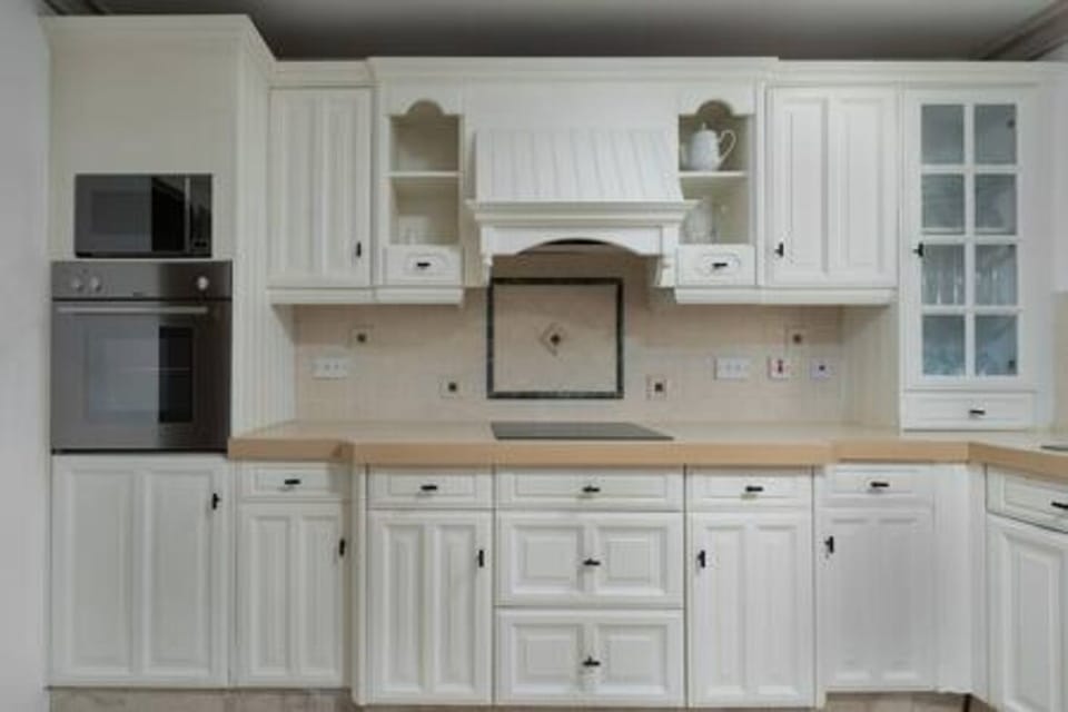 A fully equipped kitchen including a dishwasher, coffee maker, electric hob and microwave.