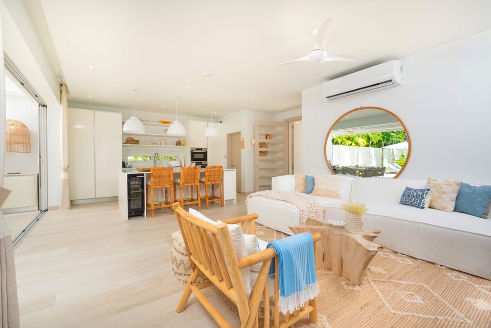 Stunning open plan living space is comfortable seating and decorated in natural tones.