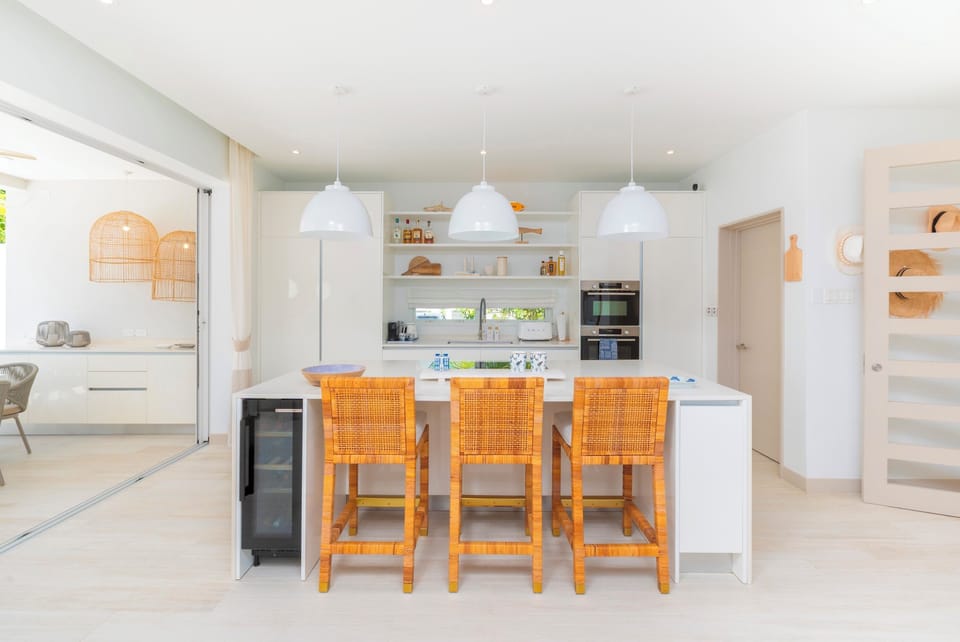 Well appointed open plan kitchen with views out to the private pool. Amenities include a blender, dishwasher, induction hob, iron and board, kettle microwave, Nespresso machine, oven, toaster, tumble dryer, washing machine and Wi-Fi throughout.