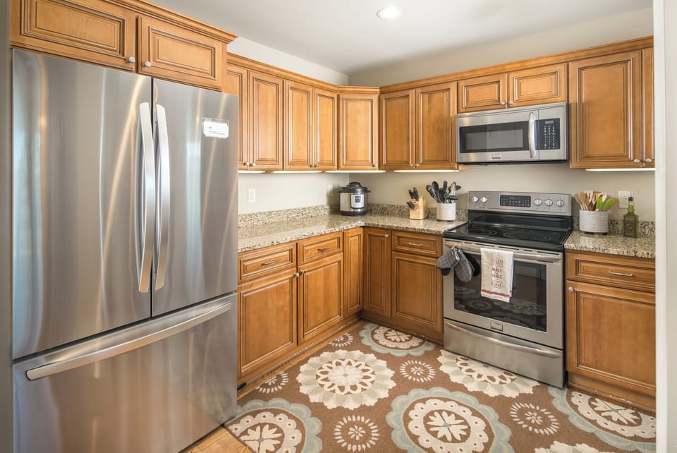 Fully equipped kitchen with wood cabinetry and stainless appliances.