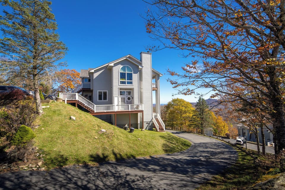 Hillside home with wraparound deck and mountain views.