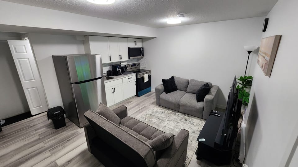 Sofa bed, kitchen, coffee maker, oven, couch, refrigerator, living area, TV