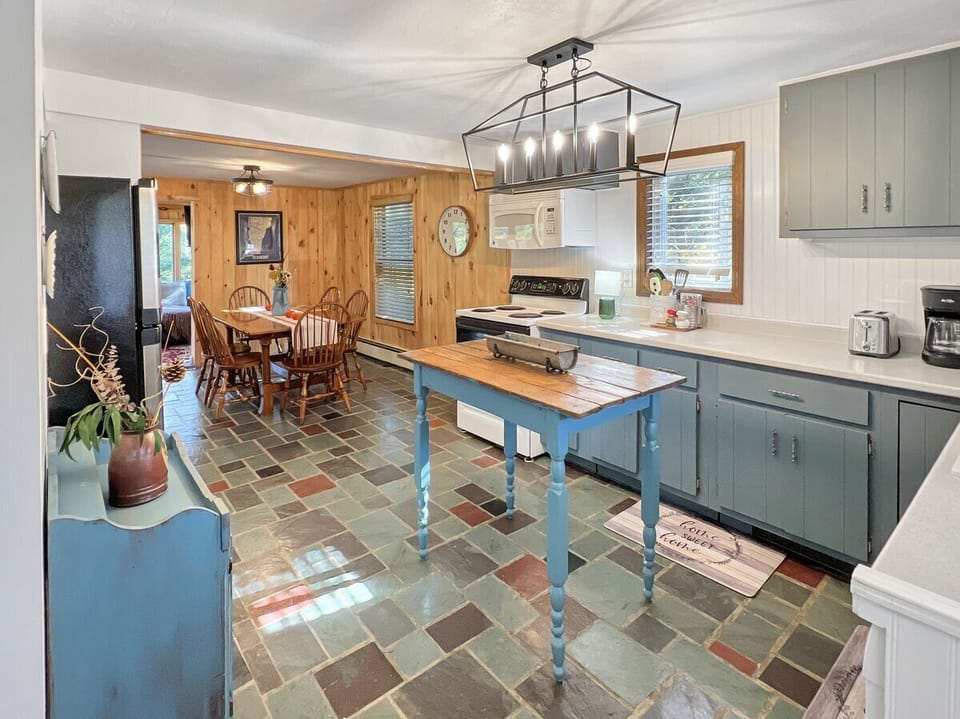 Fully equipped kitchen with electric range, ample cabinet storage, and prep space.