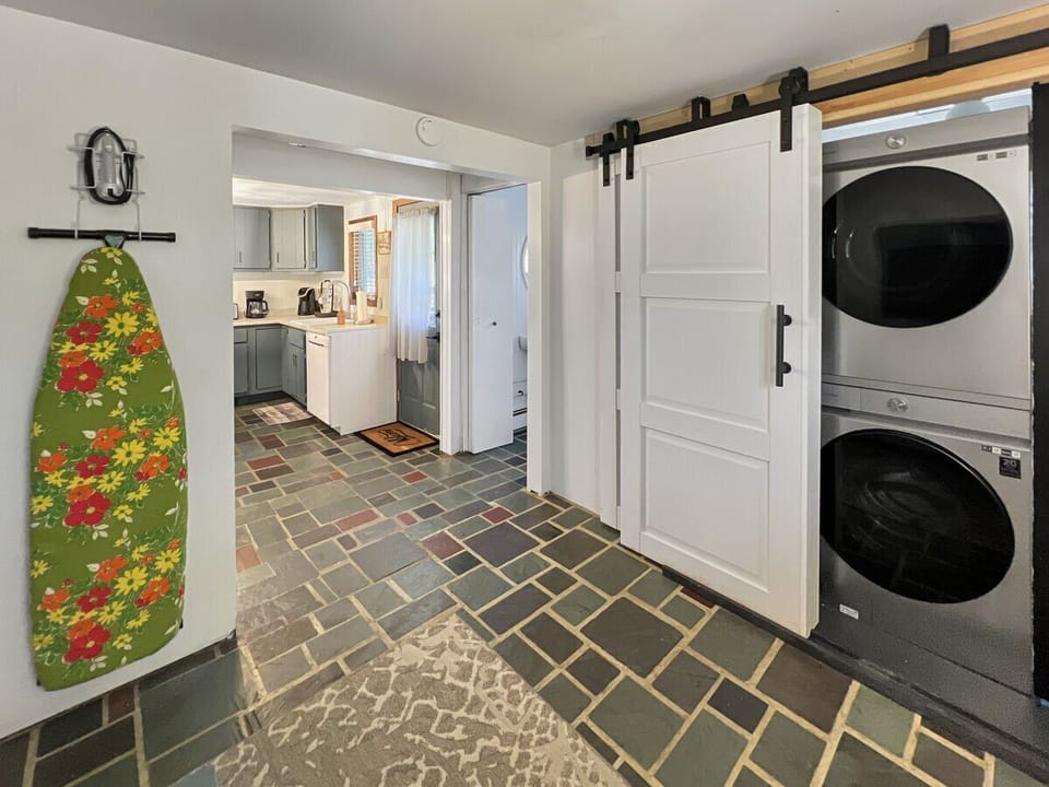 Stacked washer and dryer plus ironing board.
