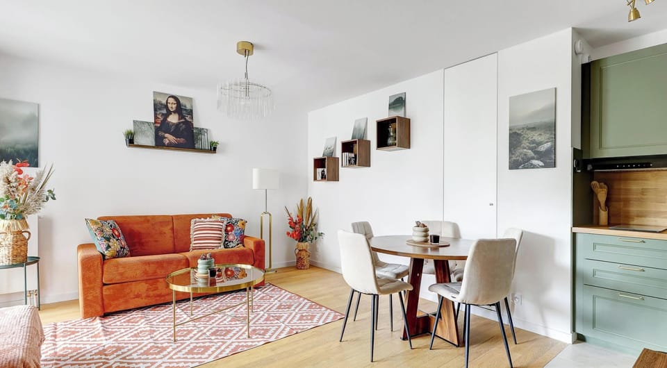 Un salon lumineux doté d’un élégant canapé convertible et d’une décoration artistique chaleureuse.