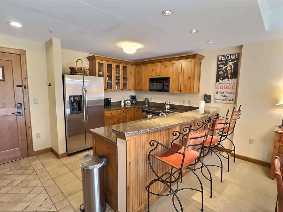 【Kitchen】Full kitchen with bar stools — guests cook full dinners here instead of eating out