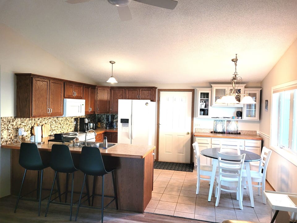 DINING AREA AND KITCHEN:  Looking into the dining area and kitchen from the living room.  (The door shown is the front entrance to the house.)