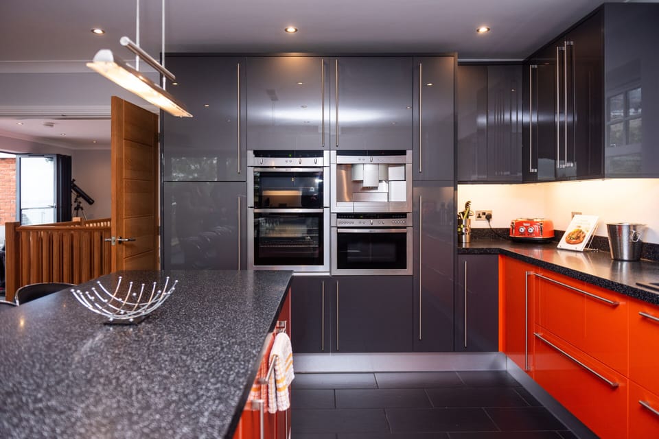 Bright open-plan kitchen with integrated appliances, full cooking facilities, and a stocked tea, coffee, and sugar station, opening onto the balcony for an easy home-from-home stay.