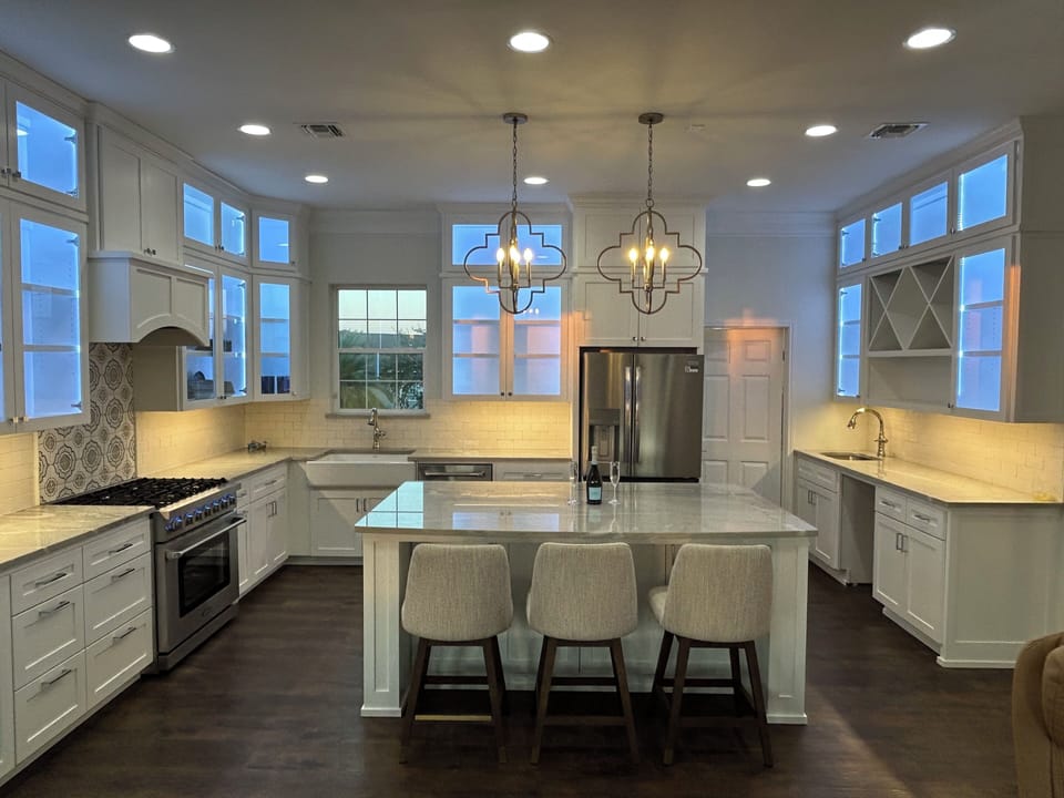 Kitchen,3 seat island bar, blue lit glass cabinets throughout