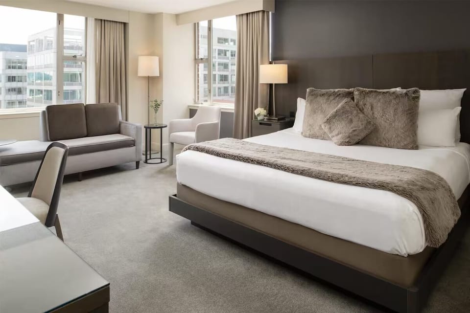 Drift off in a serene king bed with city light.