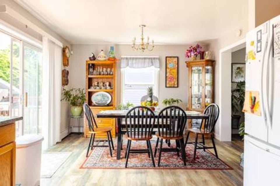 Charming and bright, this dining room blends comfort and elegance. The table for six, surrounded by natural light and warm wooden furniture, creates a cozy atmosphere perfect for family meals and special moments.