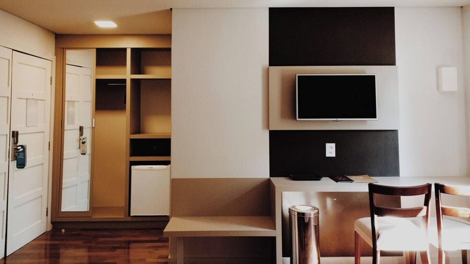Settle in with a handy workspace, TV, and in-room fridge
