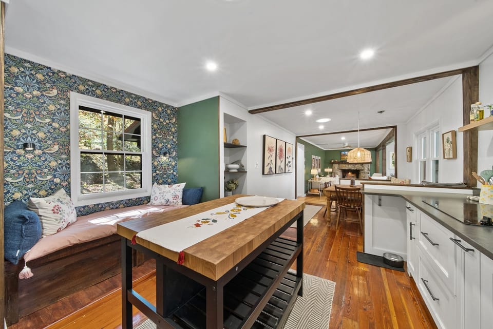 Kitchen Features a Charming Window Seat Framed by a Patterned Wall