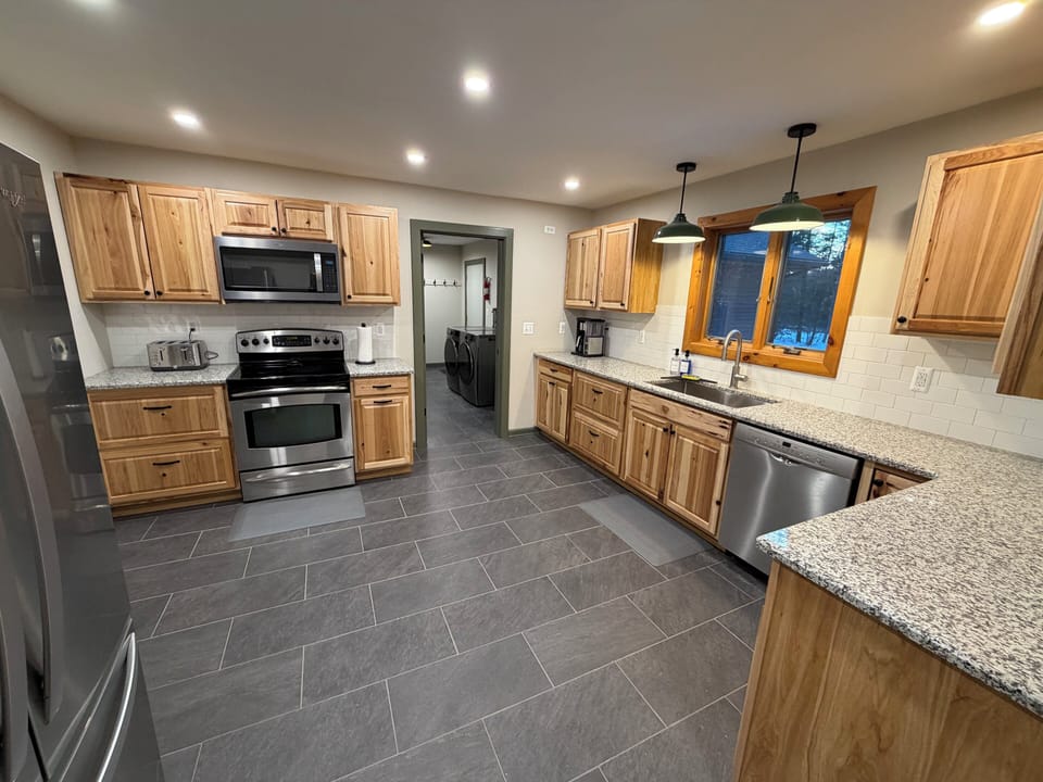Full kitchen with fridge, dishwasher, coffee maker, toaster, microwave.