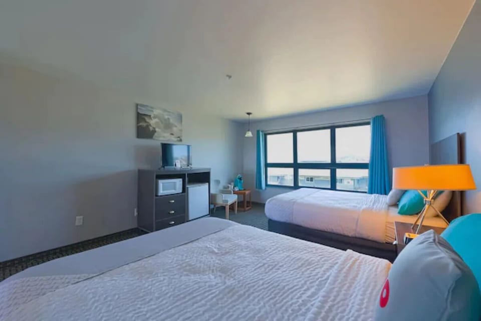 Relax together in a sunlit room with two plush beds.