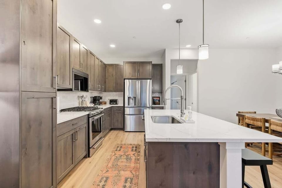 Your gourmet kitchen features sleek stainless steel appliances, spacious counters, and warm wood cabinetry for memorable meal preparations.