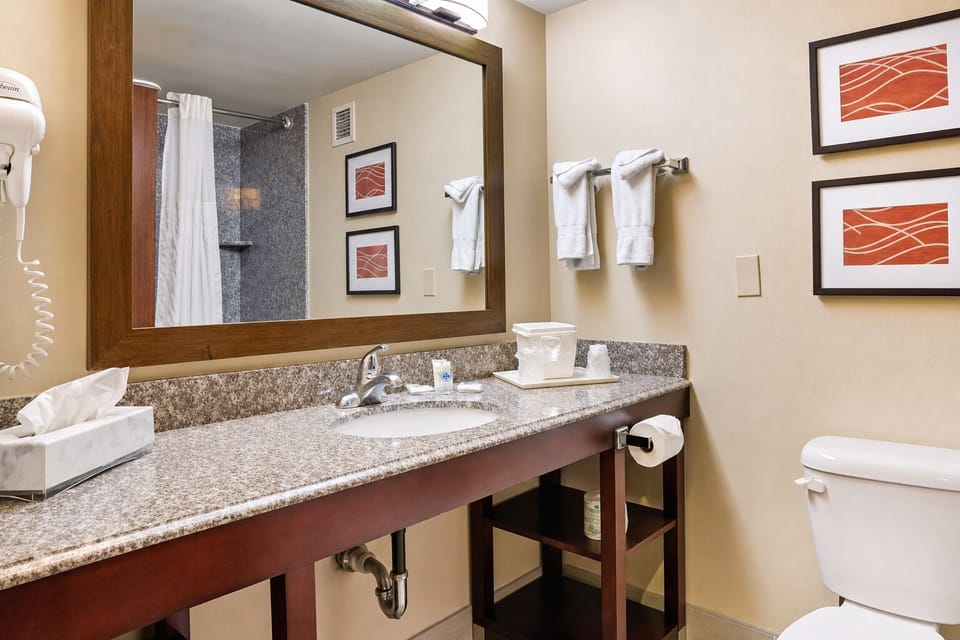 Refresh at the clean vanity with bright lighting and towels.