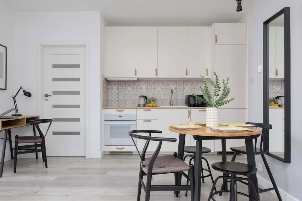 A modern kitchen in light tones with wooden accents creates a warm, homely atmosphere perfect for shared meals.