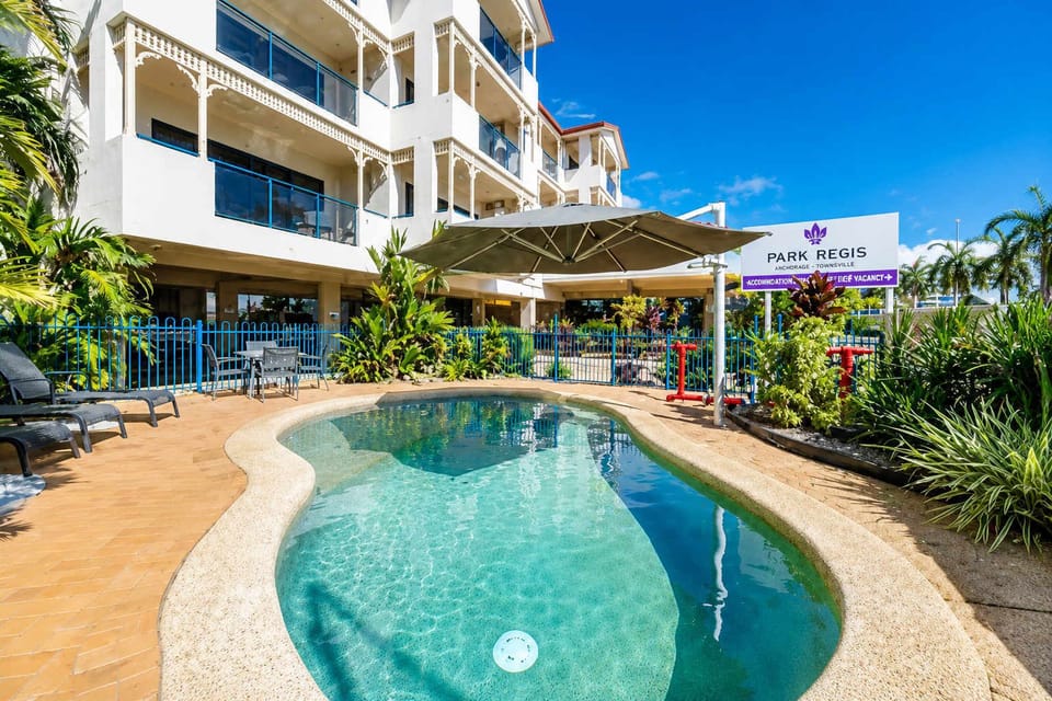 Resort-style outdoor swimming pool surrounded by tropical gardens