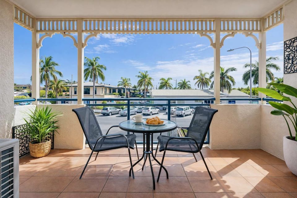 Private waterfront balcony overlooking the marina and palm-lined surrounds