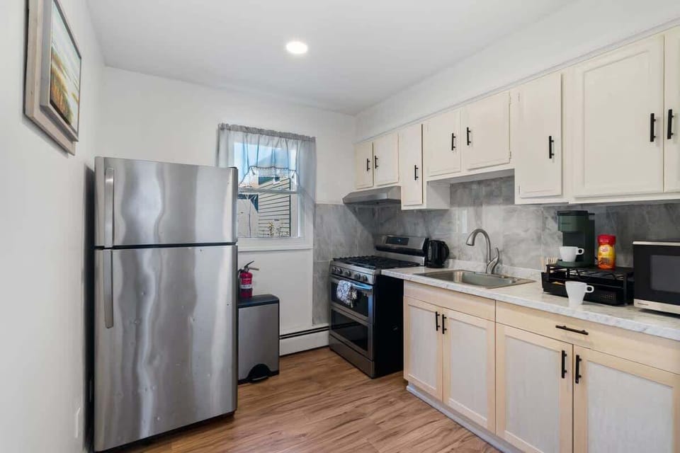 Bright, updated kitchen featuring a full-size fridge, gas stove, microwave, kettle, and coffee maker—everything you need for home-cooked comfort.
