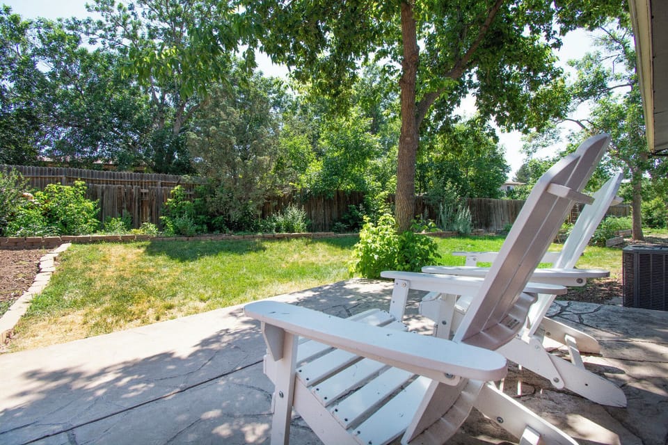 Settle into your private backyard oasis where comfortable Adirondack chairs await under the dappled shade of mature trees. You'll love sipping your morning coffee while overlooking the spacious, fenced yard.
