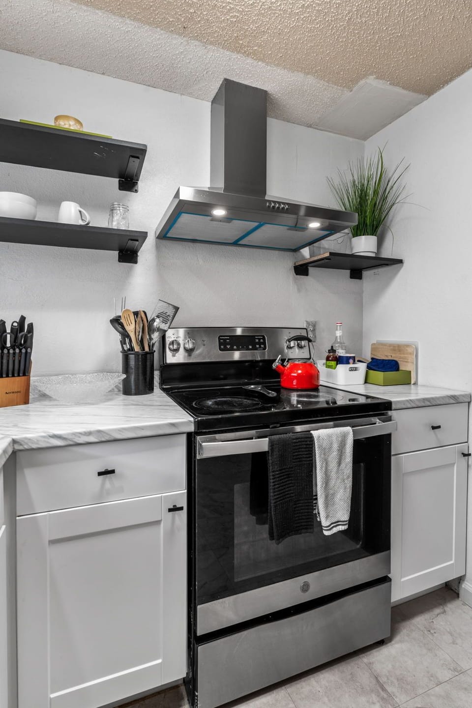 Step into your fully equipped kitchen where you can whip up home-cooked meals with modern stainless steel appliances, sleek white cabinetry, and everything you need to cook like a local.