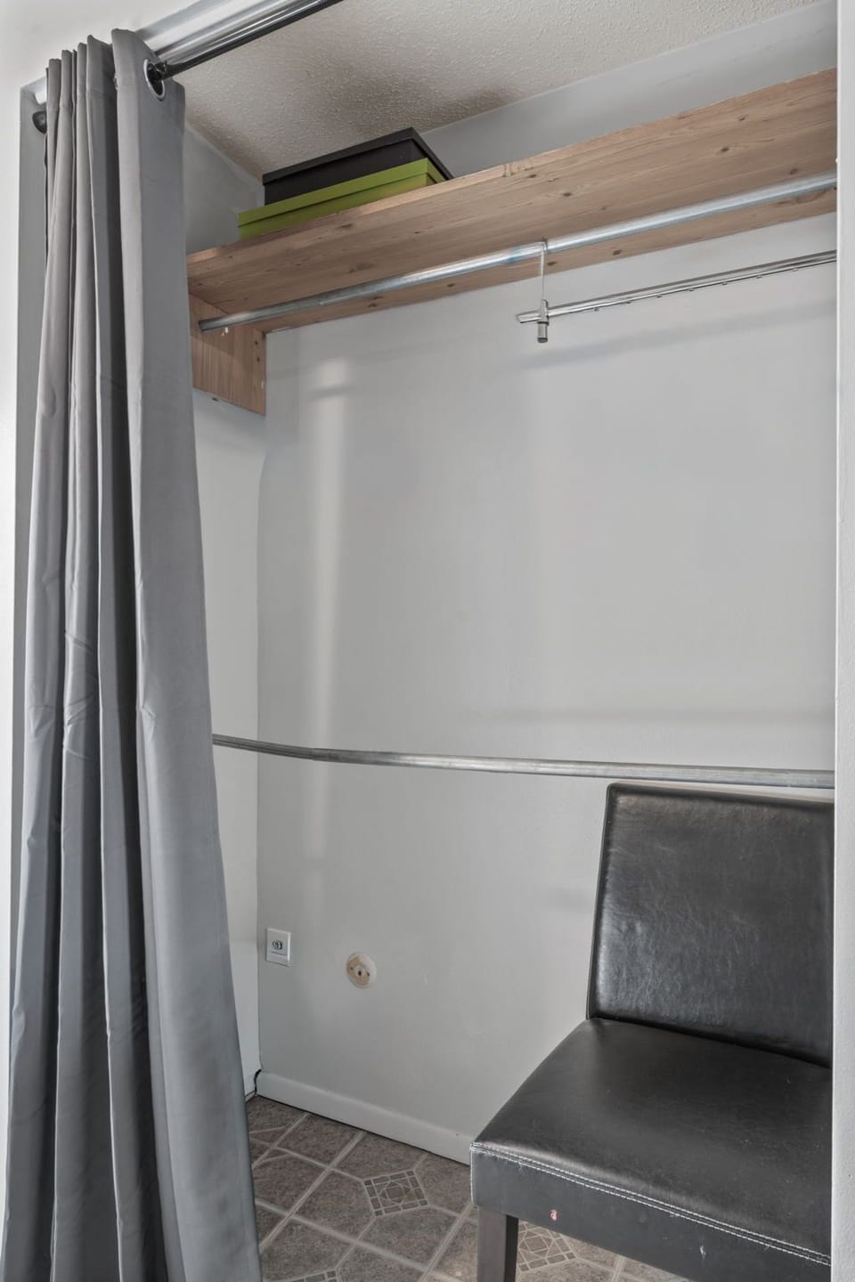 Your organized closet space features thoughtful storage with wooden shelving above and plenty of hanging room for your wardrobe, all tucked behind elegant gray curtains for a clean, private feel.