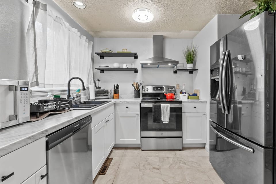 Your fully equipped kitchen awaits with gleaming stainless steel appliances and crisp white cabinetry. Cook your favorite meals with modern conveniences at your fingertips.