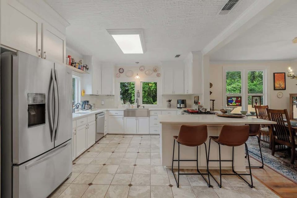 Open-Concept Kitchen with Bar Seating & Dining Room View.  This stylish open kitchen flows seamlessly into the dining area, creating the perfect space for cooking, entertaining, or simply enjoying conversation over a meal.
